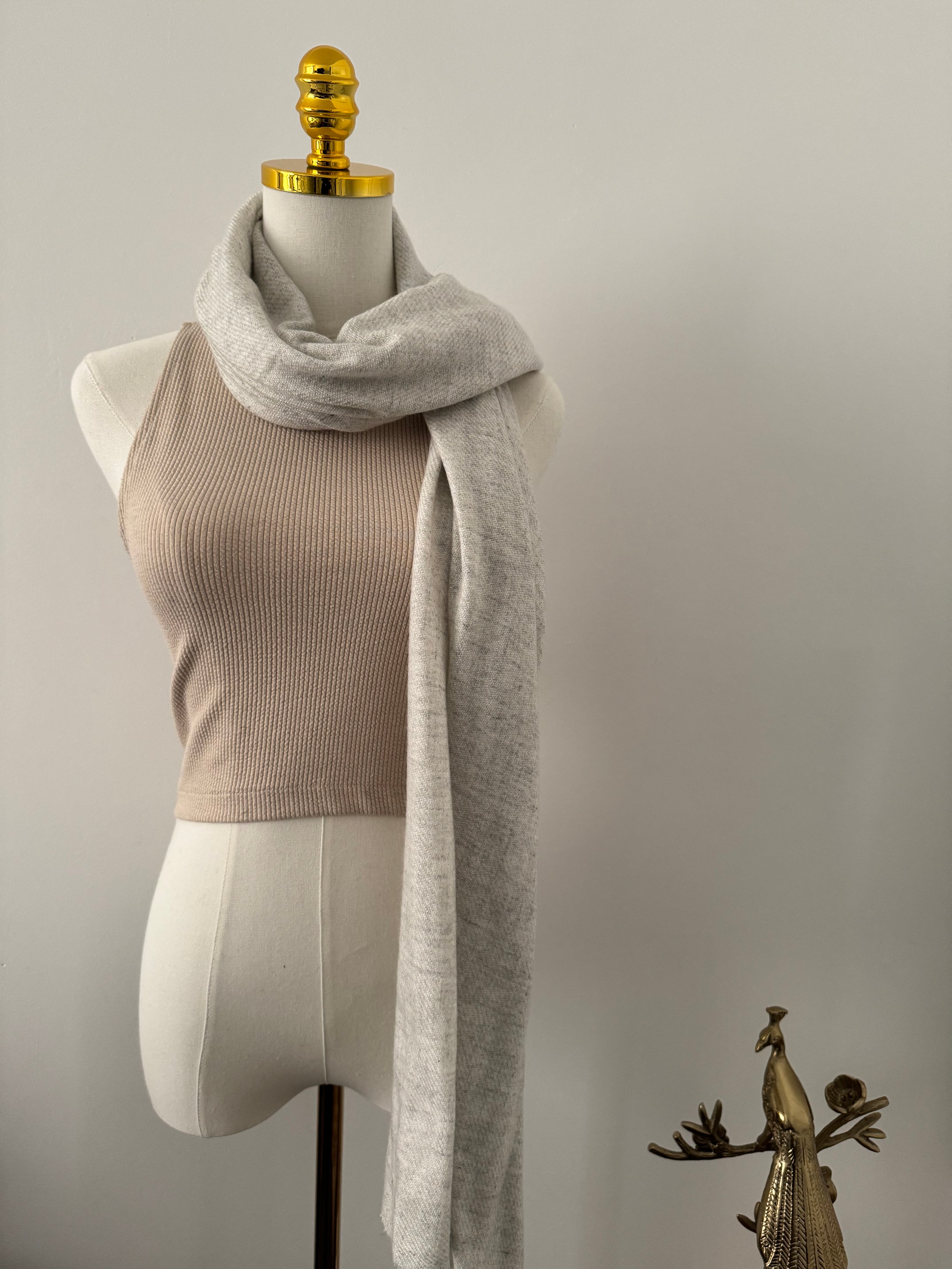 Mannequin wearing a gray shawl on a white background