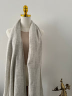 Light gray fabric on a mannequin with gold accents against a neutral background