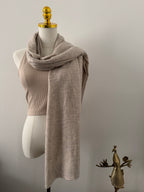 Mannequin wearing a beige scarf on a plain background