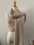 Decorative beige fabric shawl on a plain background