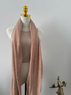 Mannequin wearing a light brown fabric on a plain background