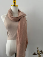 Mannequin wearing a beige shawlwith a plain background