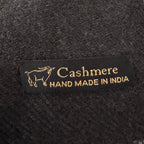 Label on dark fabric indicating 'Cashmere Hand Made in India'.