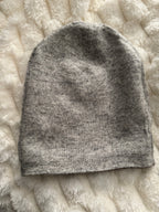Gray knitted sock on a textured white surface