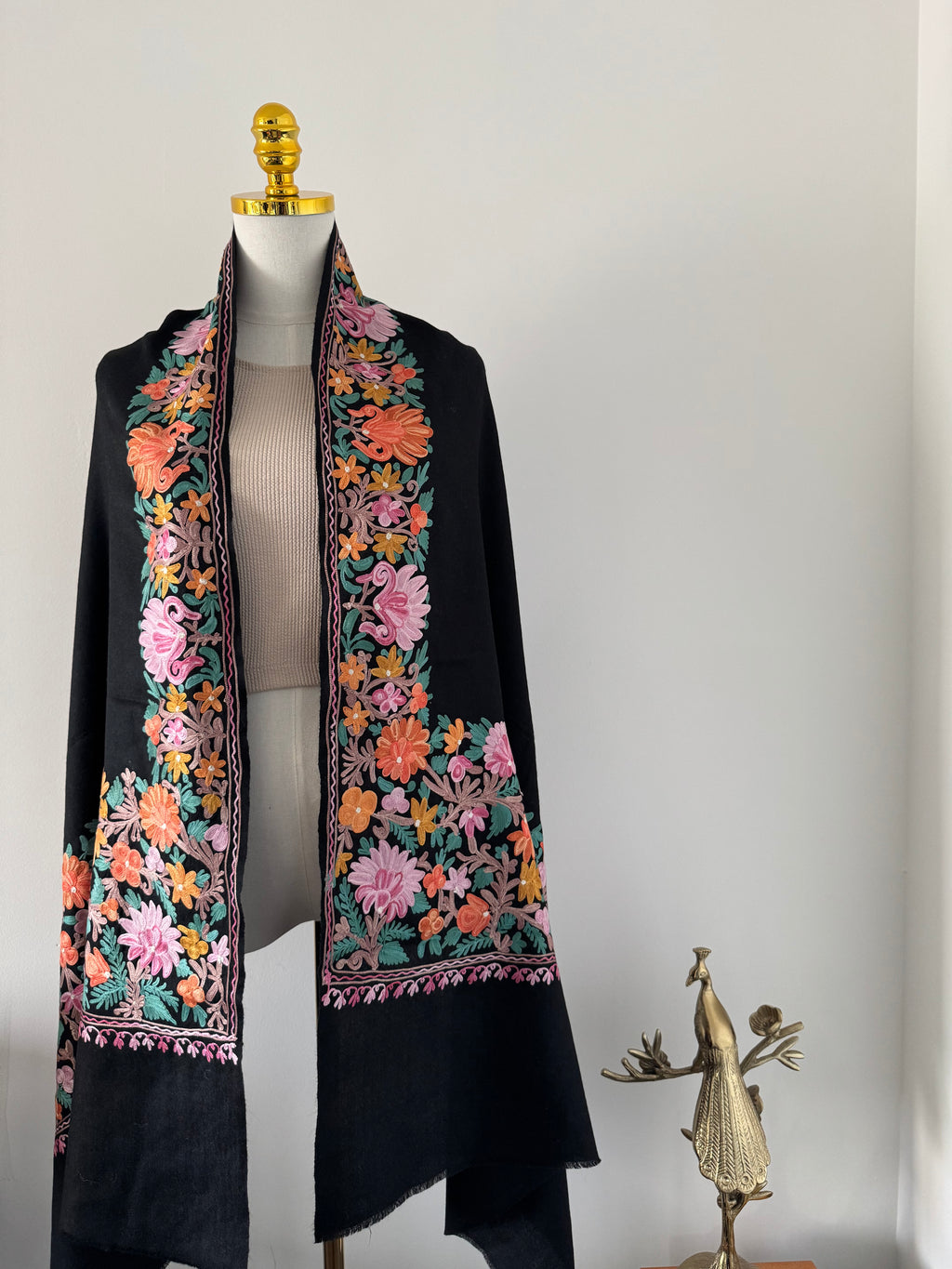 Decorative black shawl with floral embroidery on a white background
