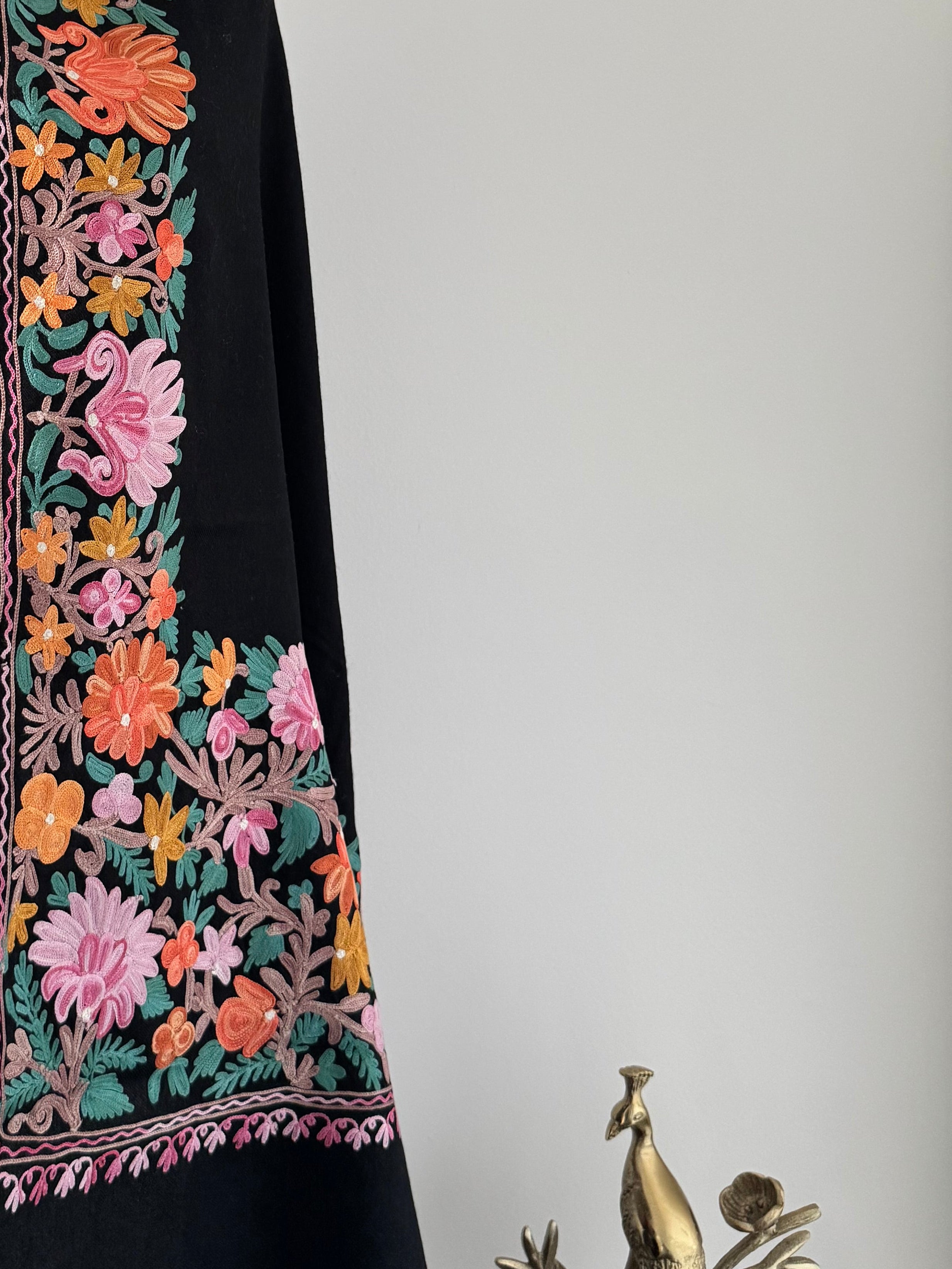 Decorative shawl with floral embroidery on a white background