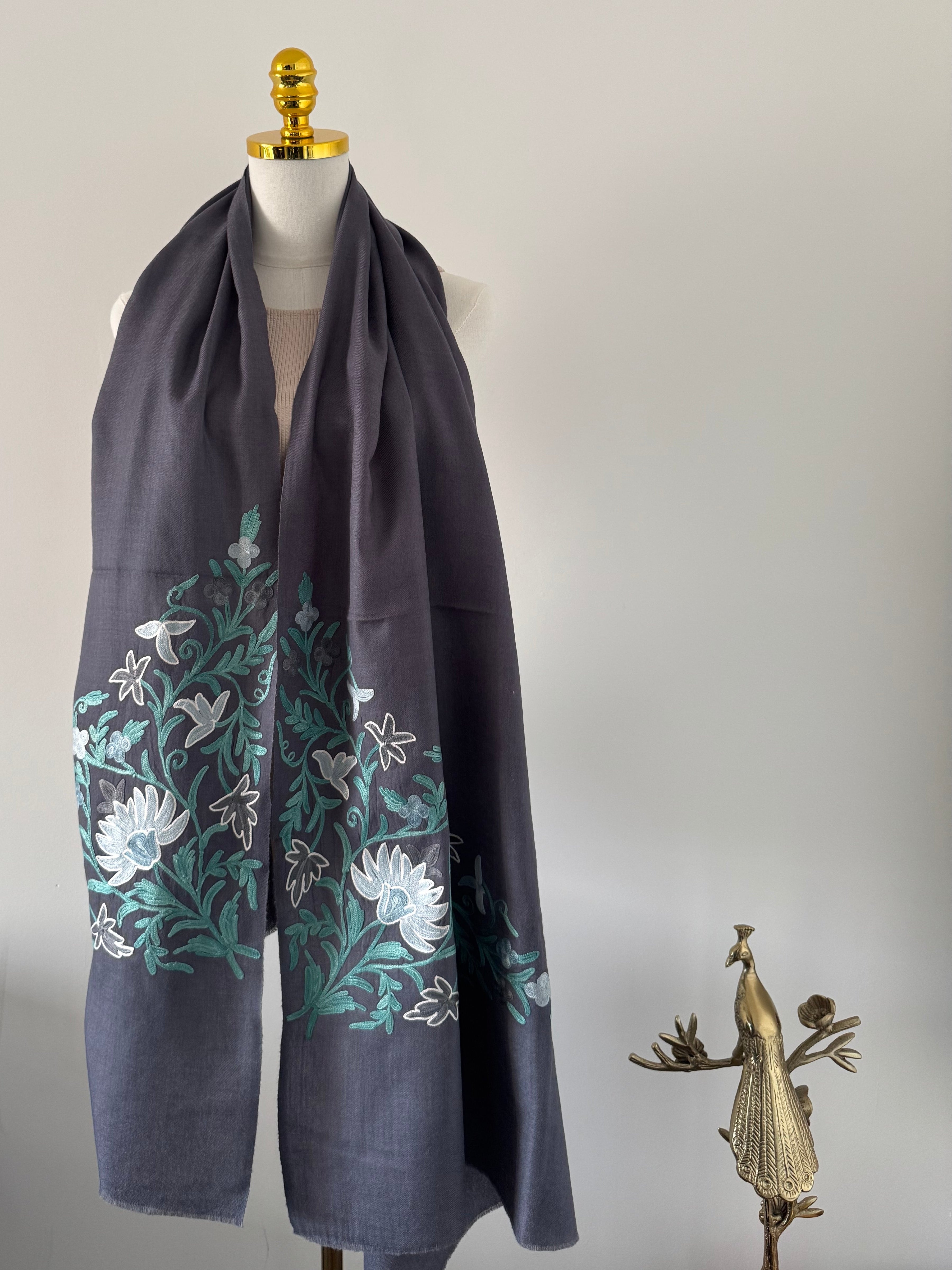 Dark fabric with floral embroidery on a white wall