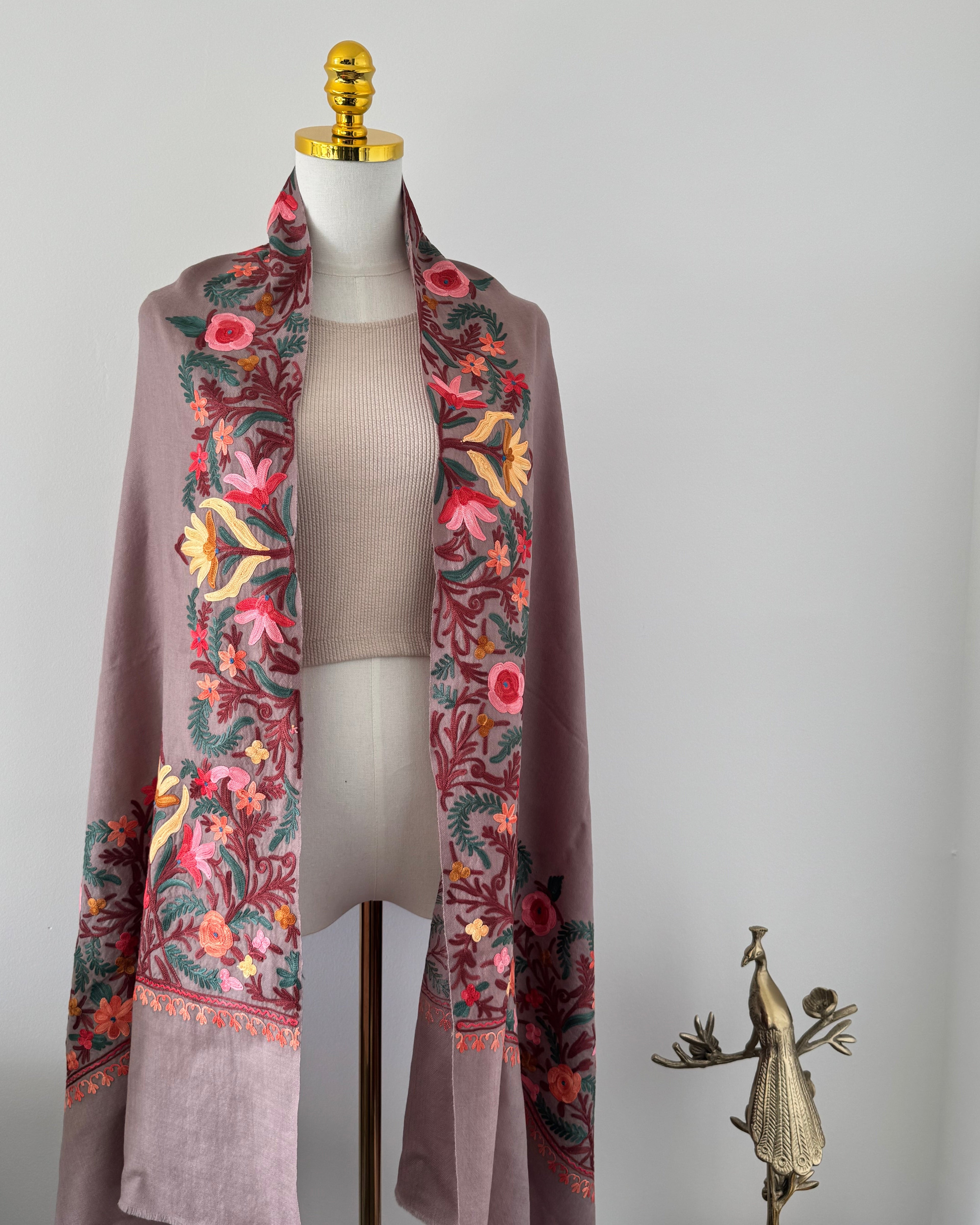 Decorative fabric with floral patterns on a mannequin against a plain background