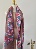 Floral embroidered scarf on a mannequin against a plain background