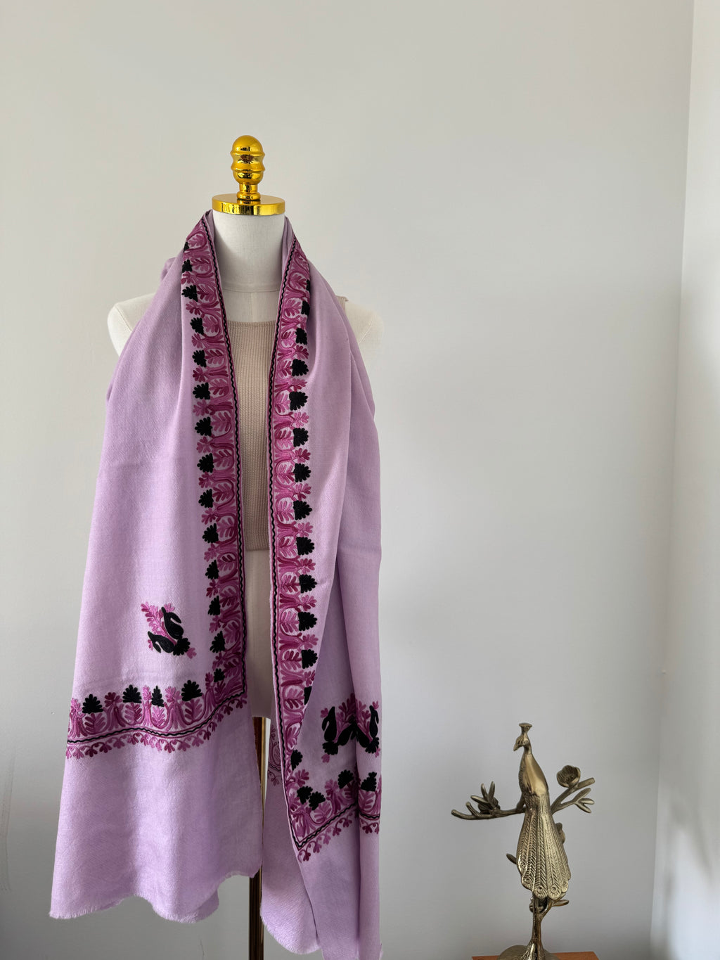 Purple fabric with black and pink embroidery on a white background