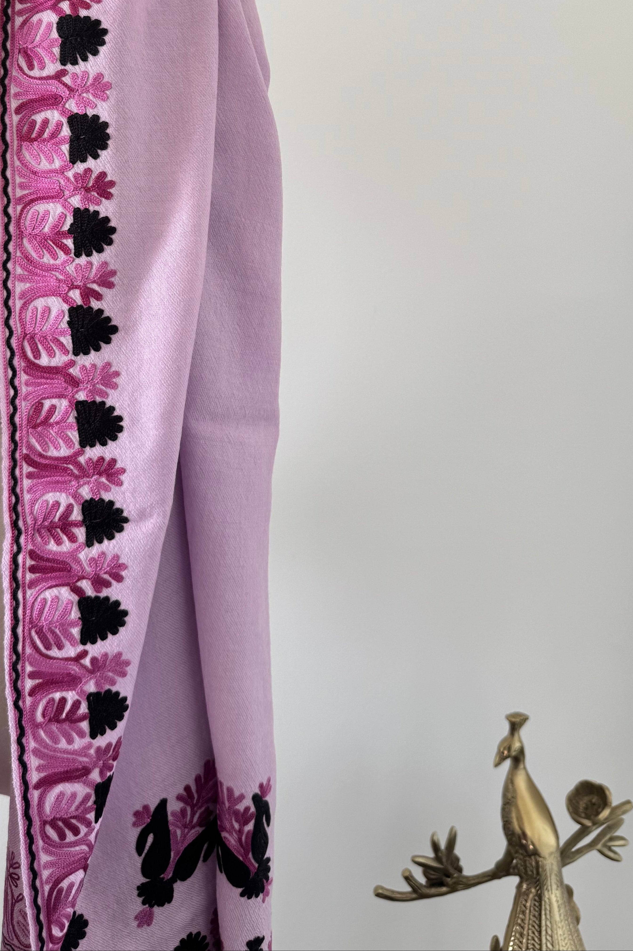 Folded purple fabric with black floral patterns on a white background