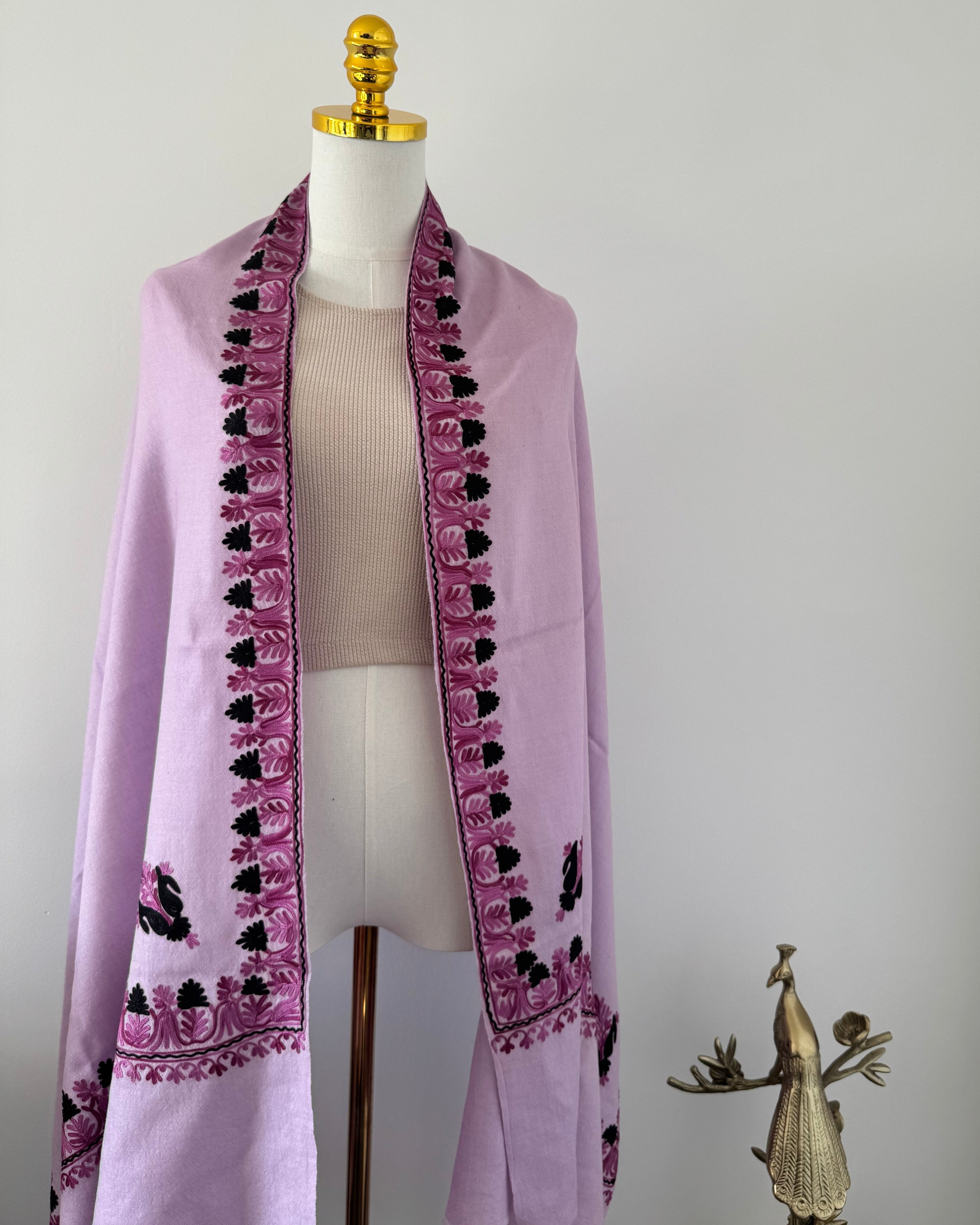 Purple shawl with black embroidery on a mannequin against a white background