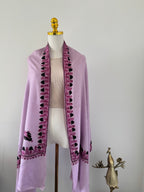 Purple fabric with pink embroidery on a white background