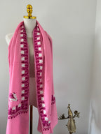 Pink shawl with white embroidery on a white background