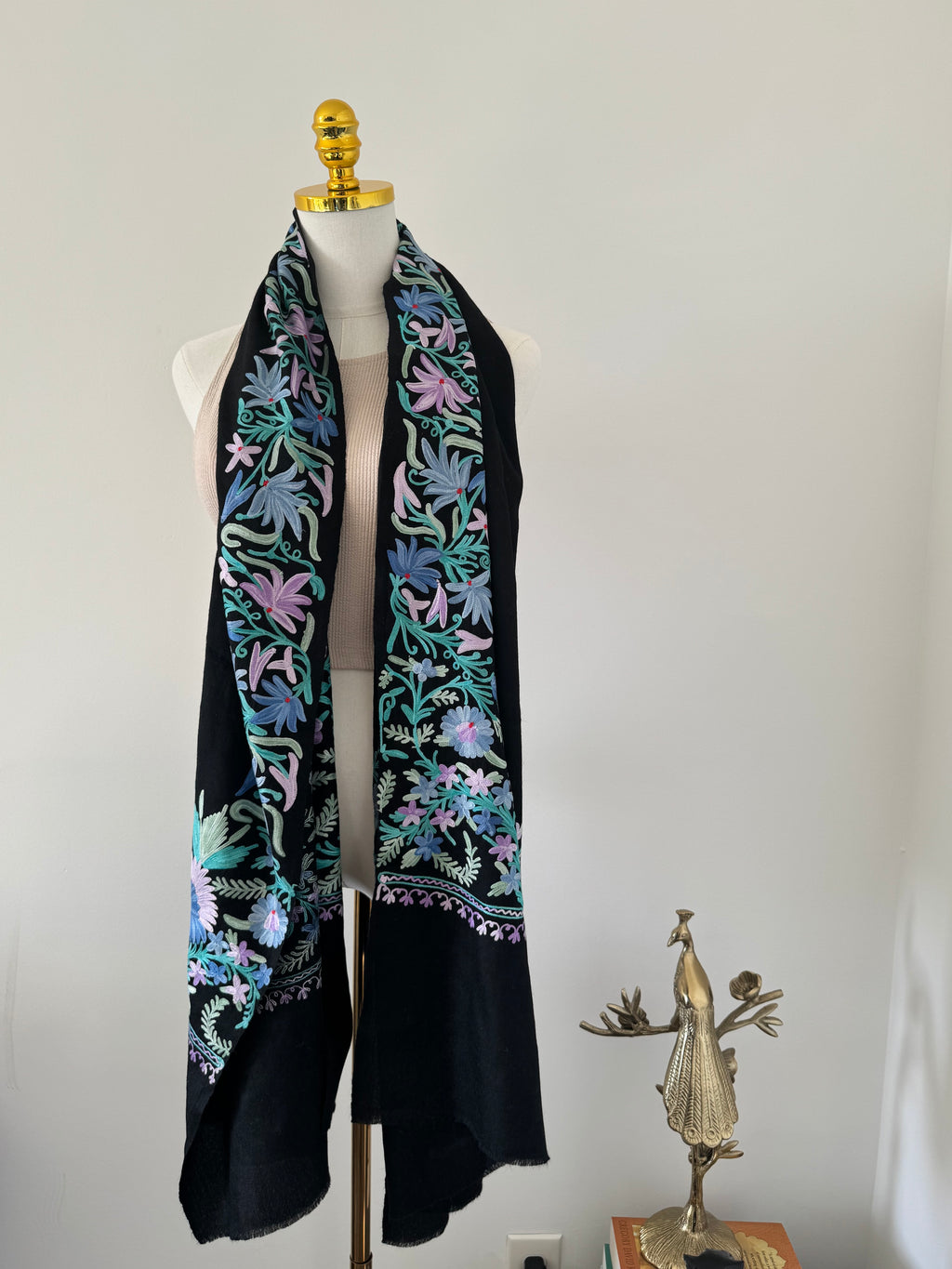 Black shawl with colorful floral embroidery on a white background