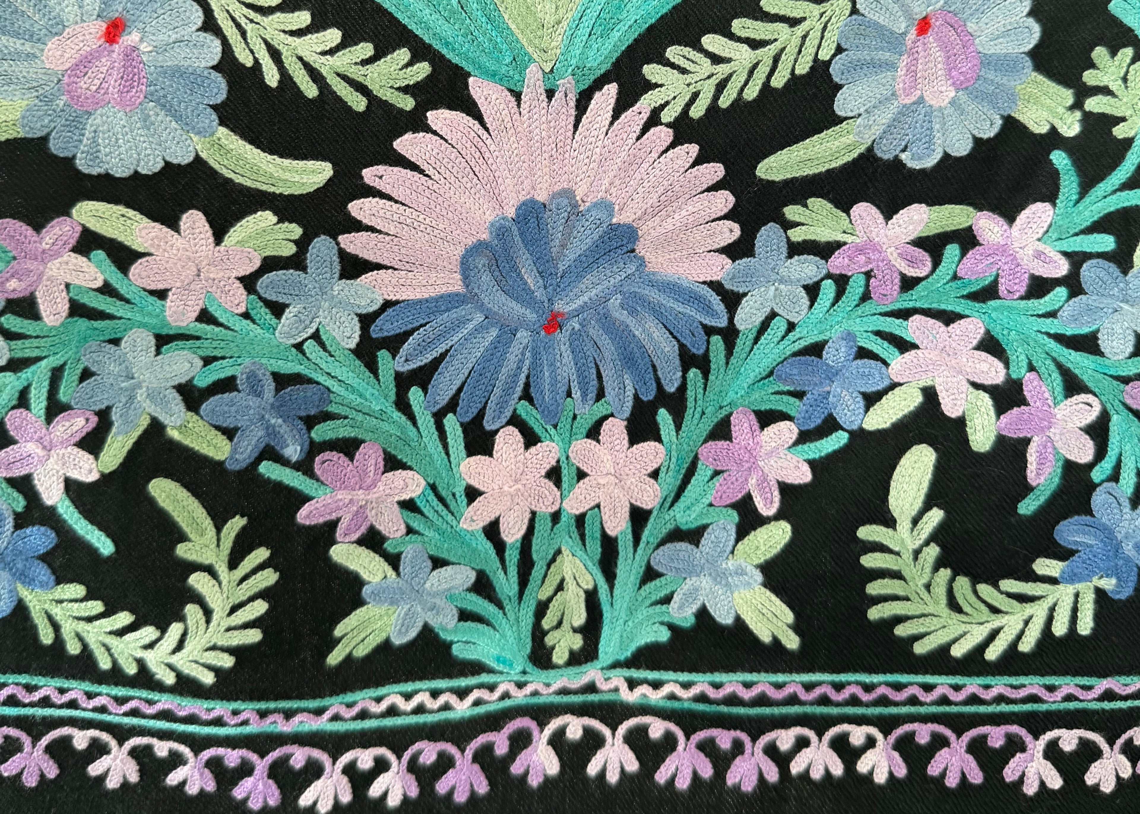 Close-up of black fabric with colorful floral embroidery