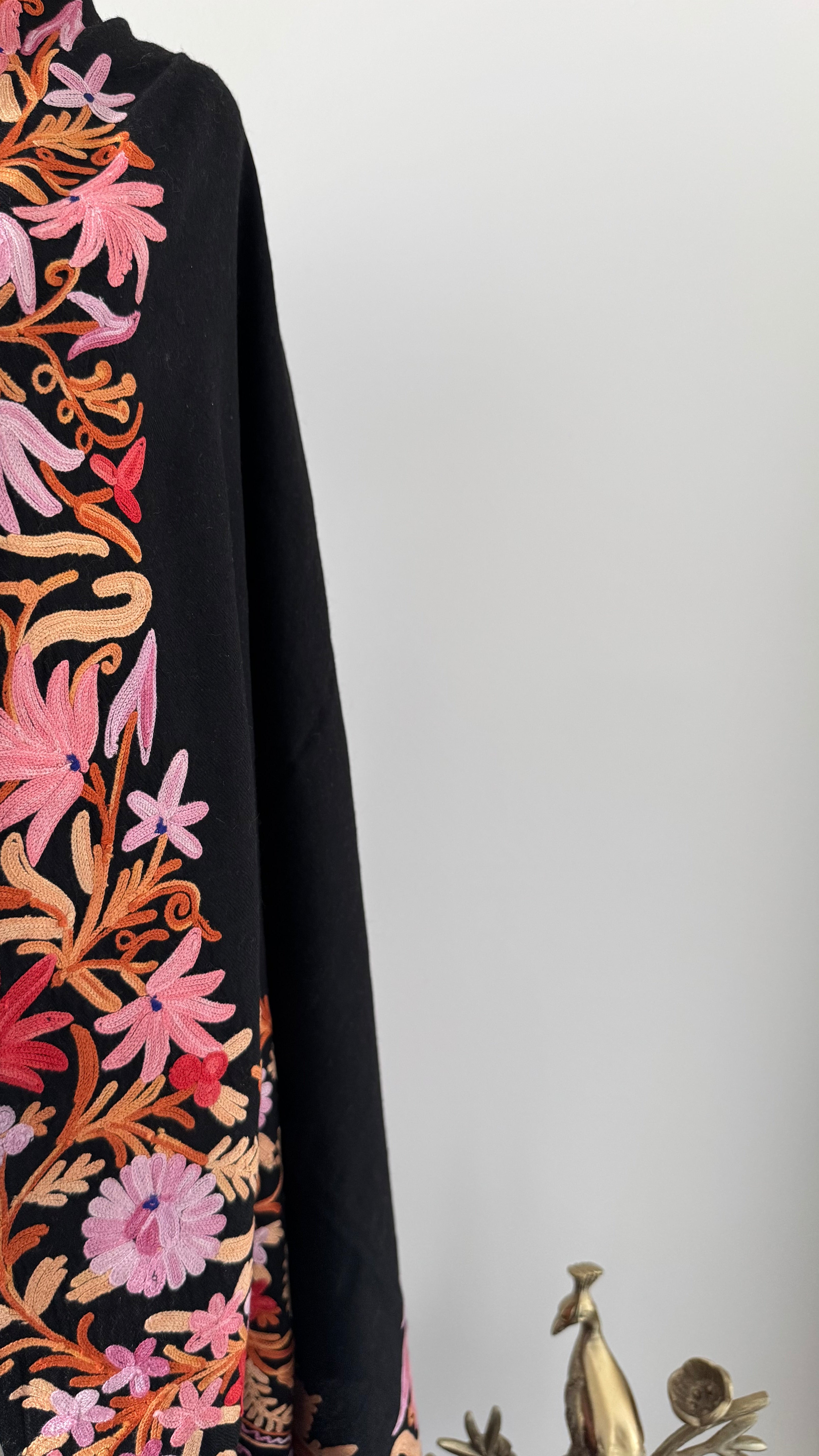 Black shawl with colorful floral embroidery on a white background