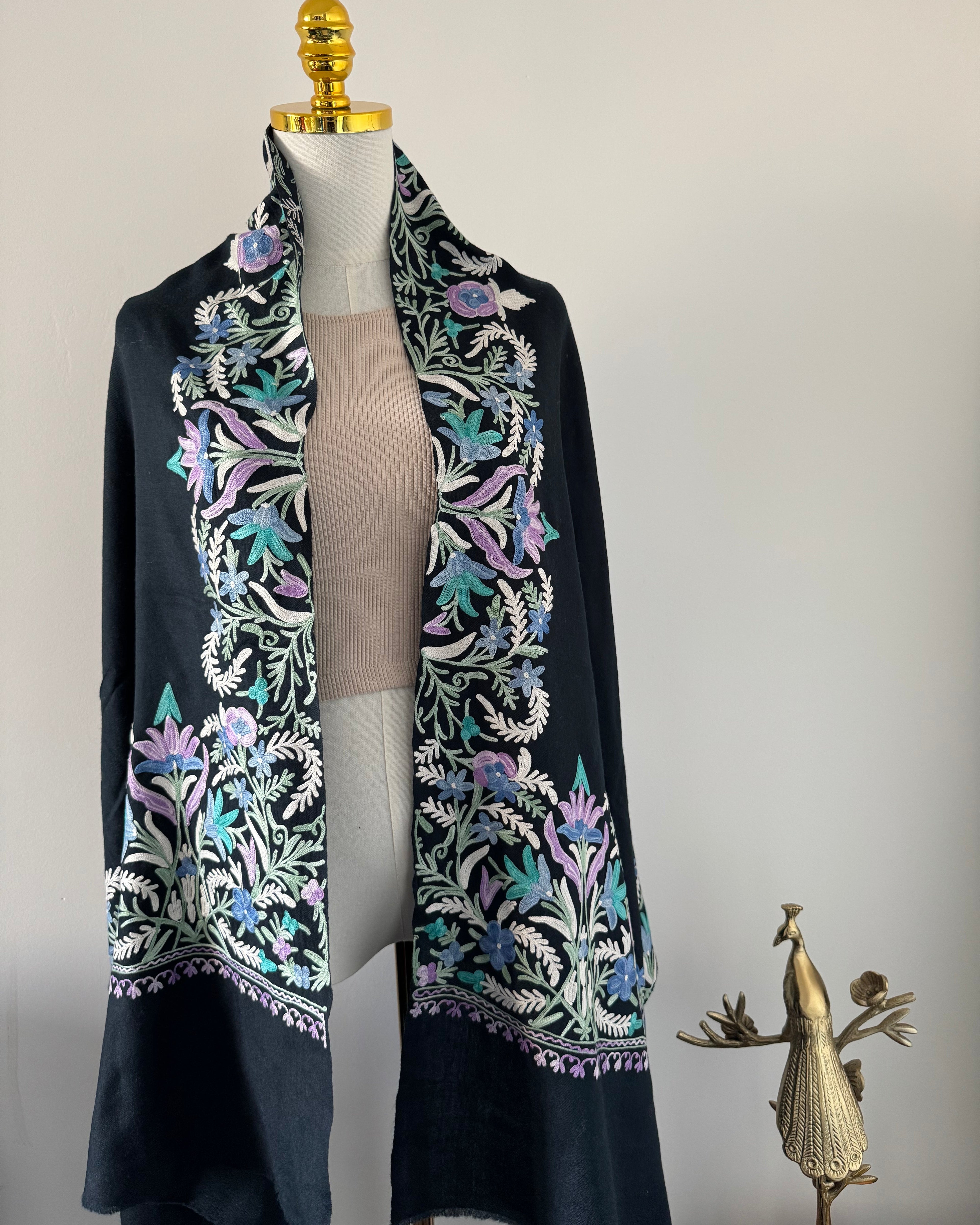 Embroidered fabric with floral patterns on a mannequin against a neutral background