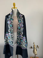 Navy blue fabric with intricate floral embroidery on a mannequin against a neutral background