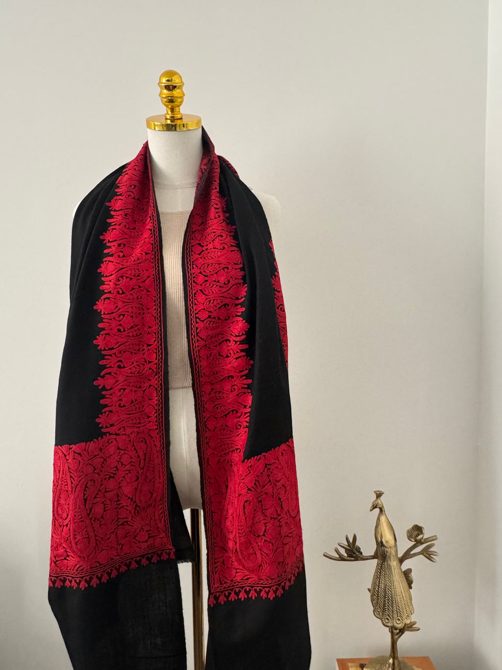 Red and black with intricate patterns on a mannequin against a neutral background
