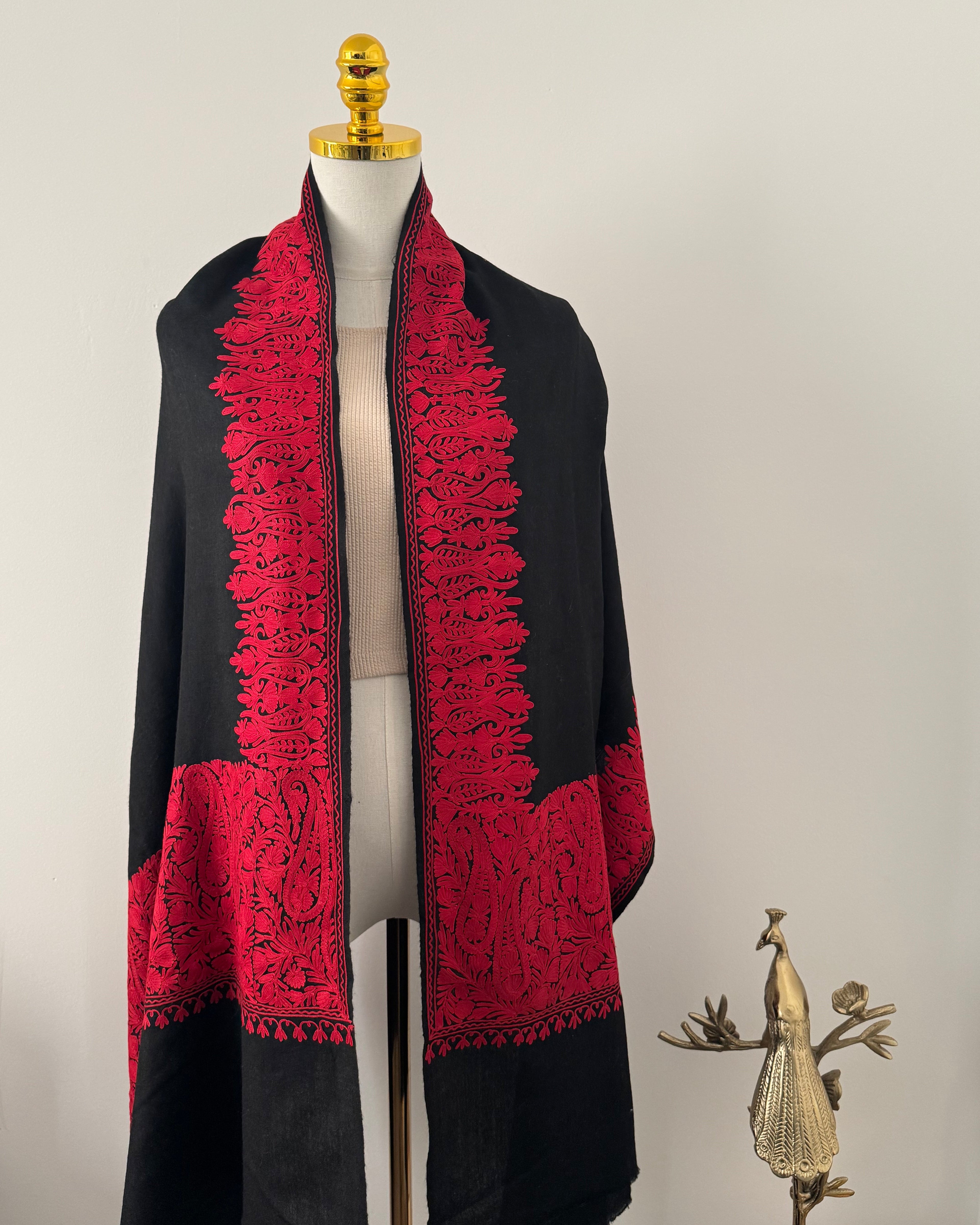 Black shawl with red lace details on a white background