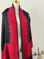 Black fabric with red lace detailing on a white background