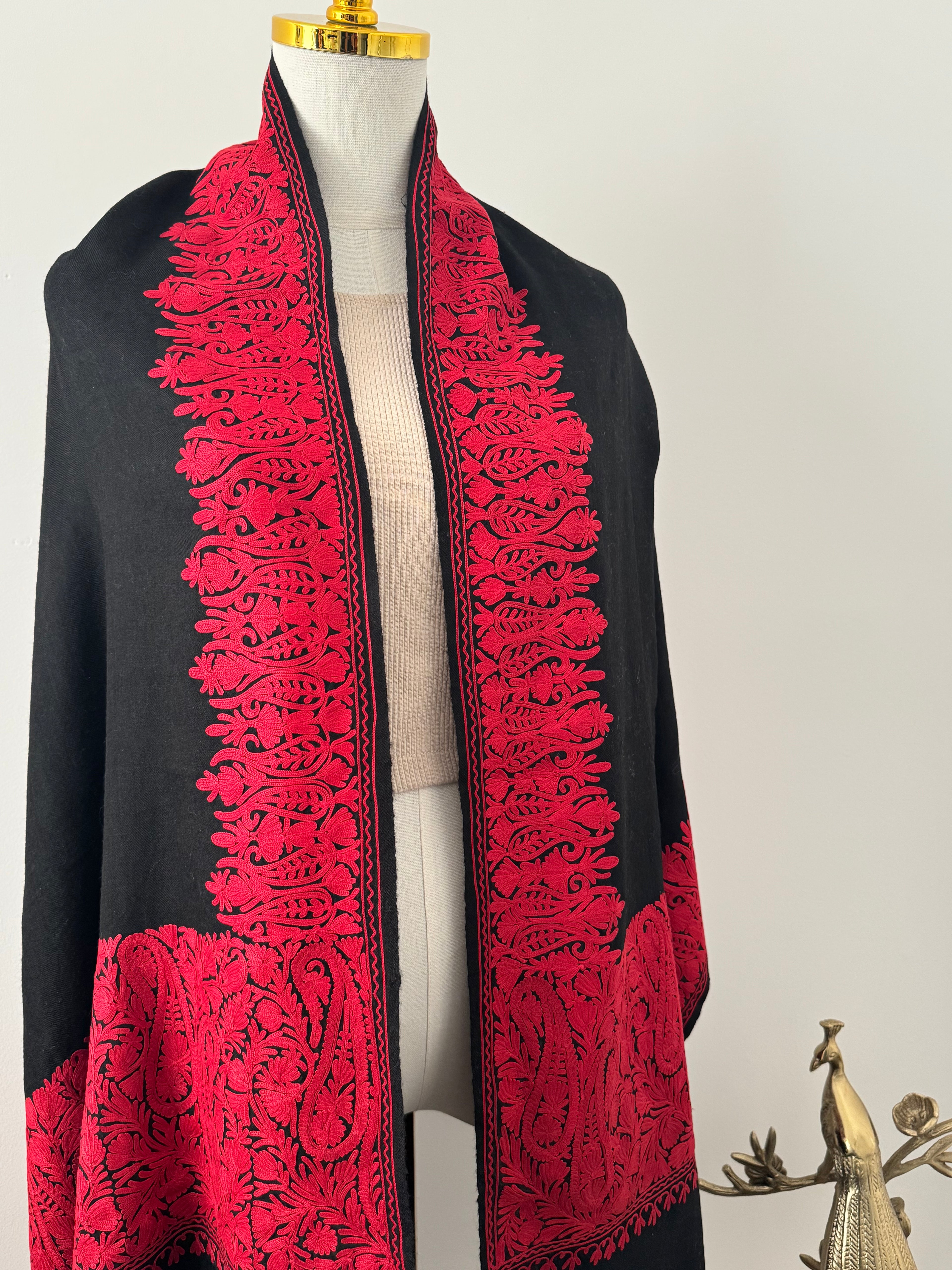 Black fabric with red lace detailing on a white background