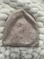 Brown knitted blanket on a textured white surface
