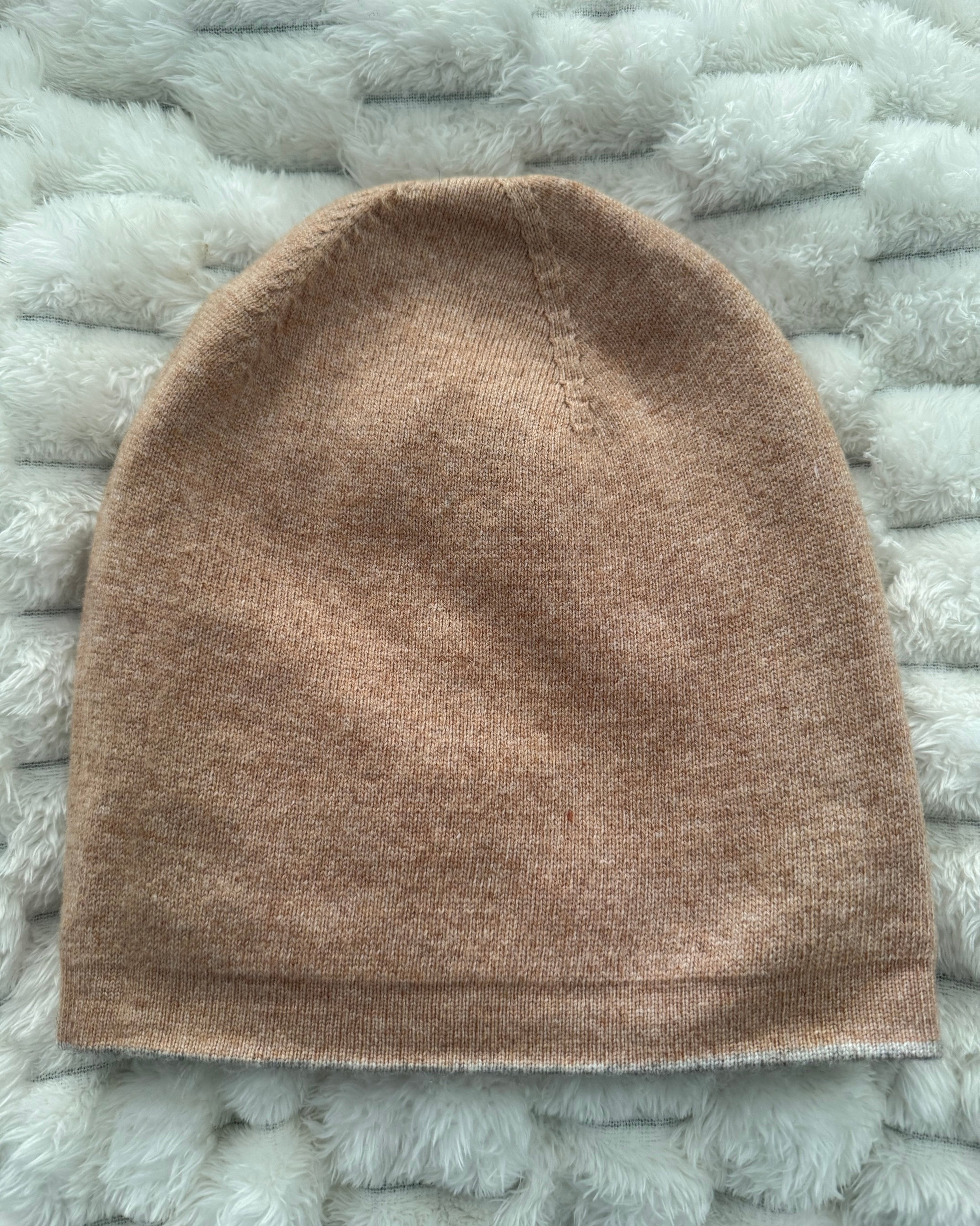 Brown knitted beanie on a textured gray surface