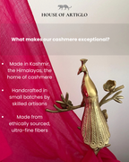 Gold peacock statue with pink fabric and text about cashmere quality, House of Artiglo branding.