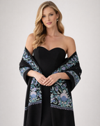 Woman wearing a black dress with a floral shawl on a white background