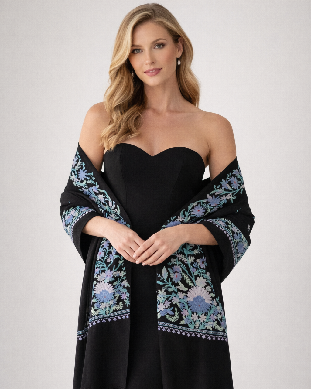 Woman wearing a black dress with a floral shawl on a white background