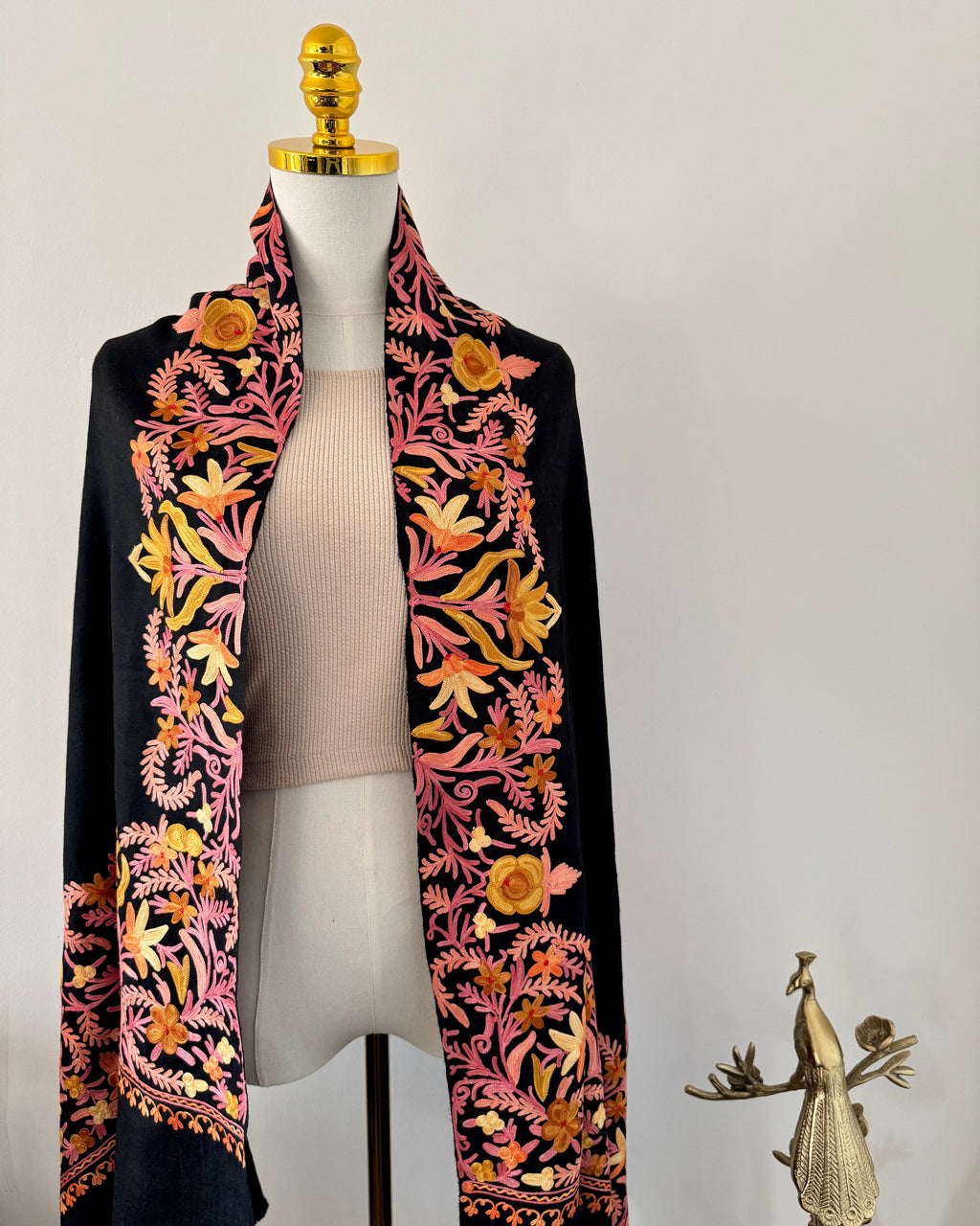 Black embroidered shawl on a mannequin with a white background