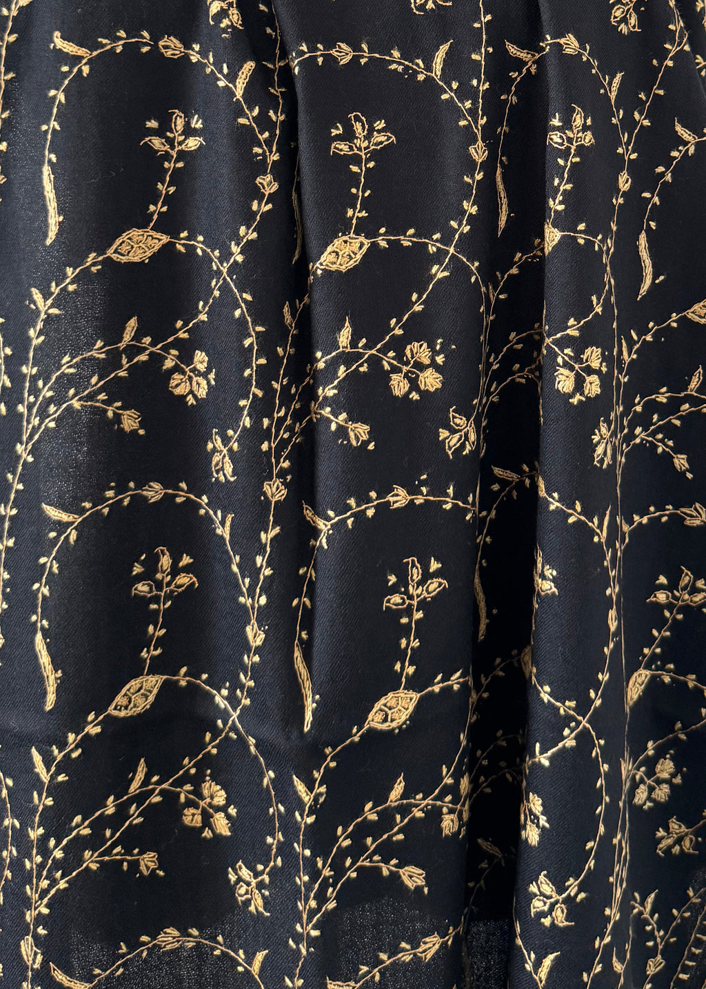 Black fabric with gold floral pattern on a white background