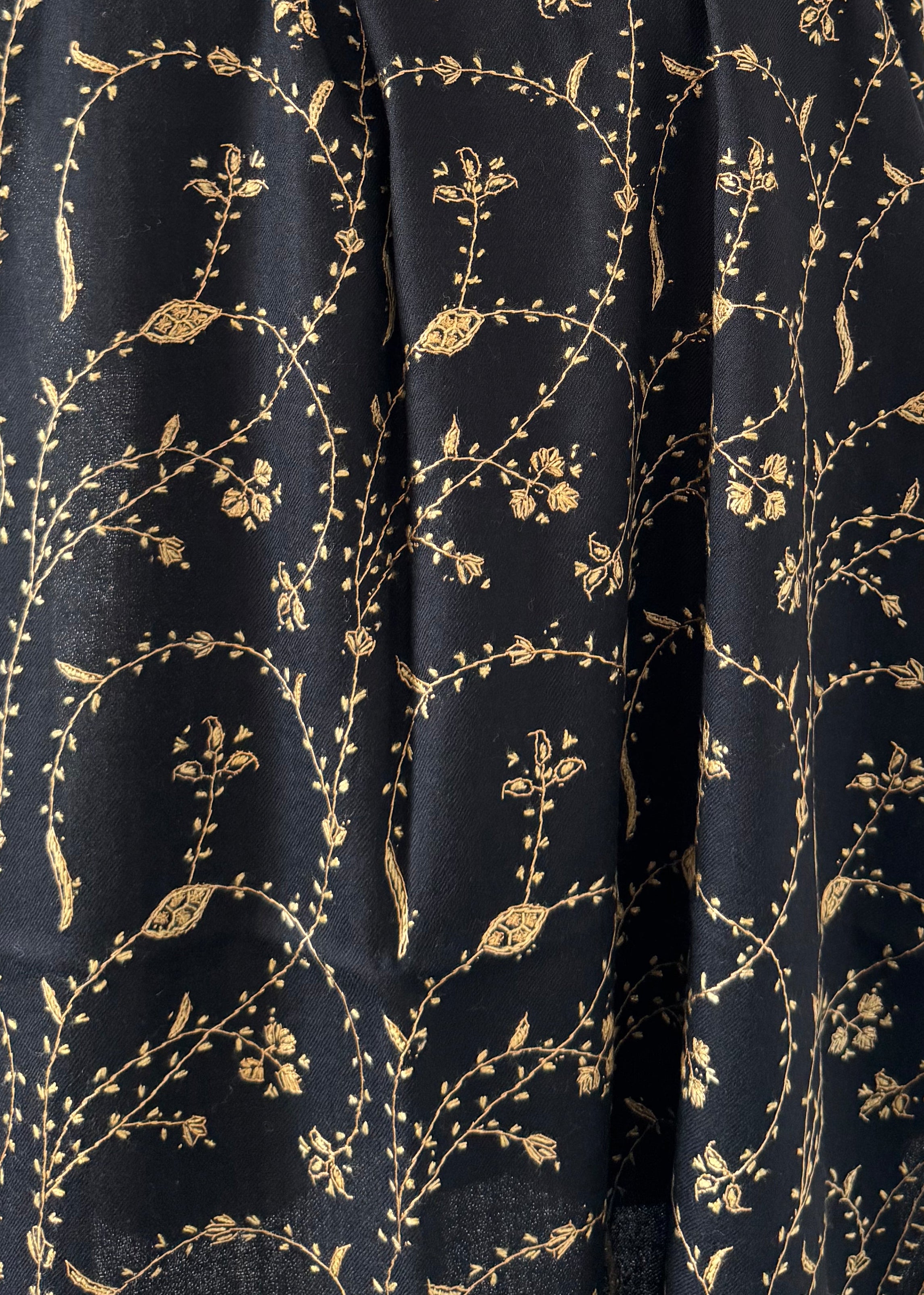 Black fabric with gold floral pattern on a white background