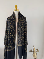 Decorative black and gold shawl on a white background