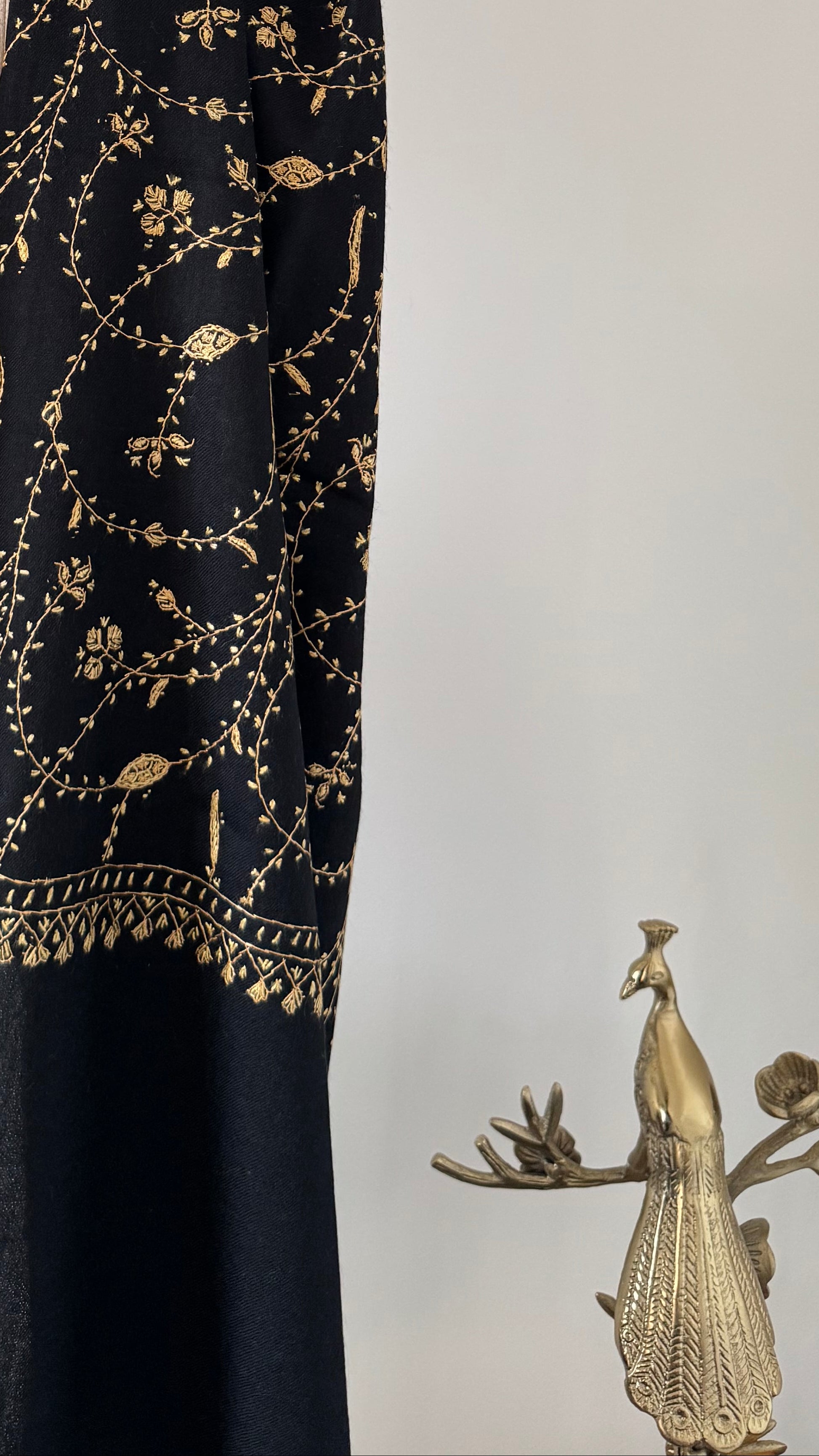 Decorative shawl with gold embroidery on a white background