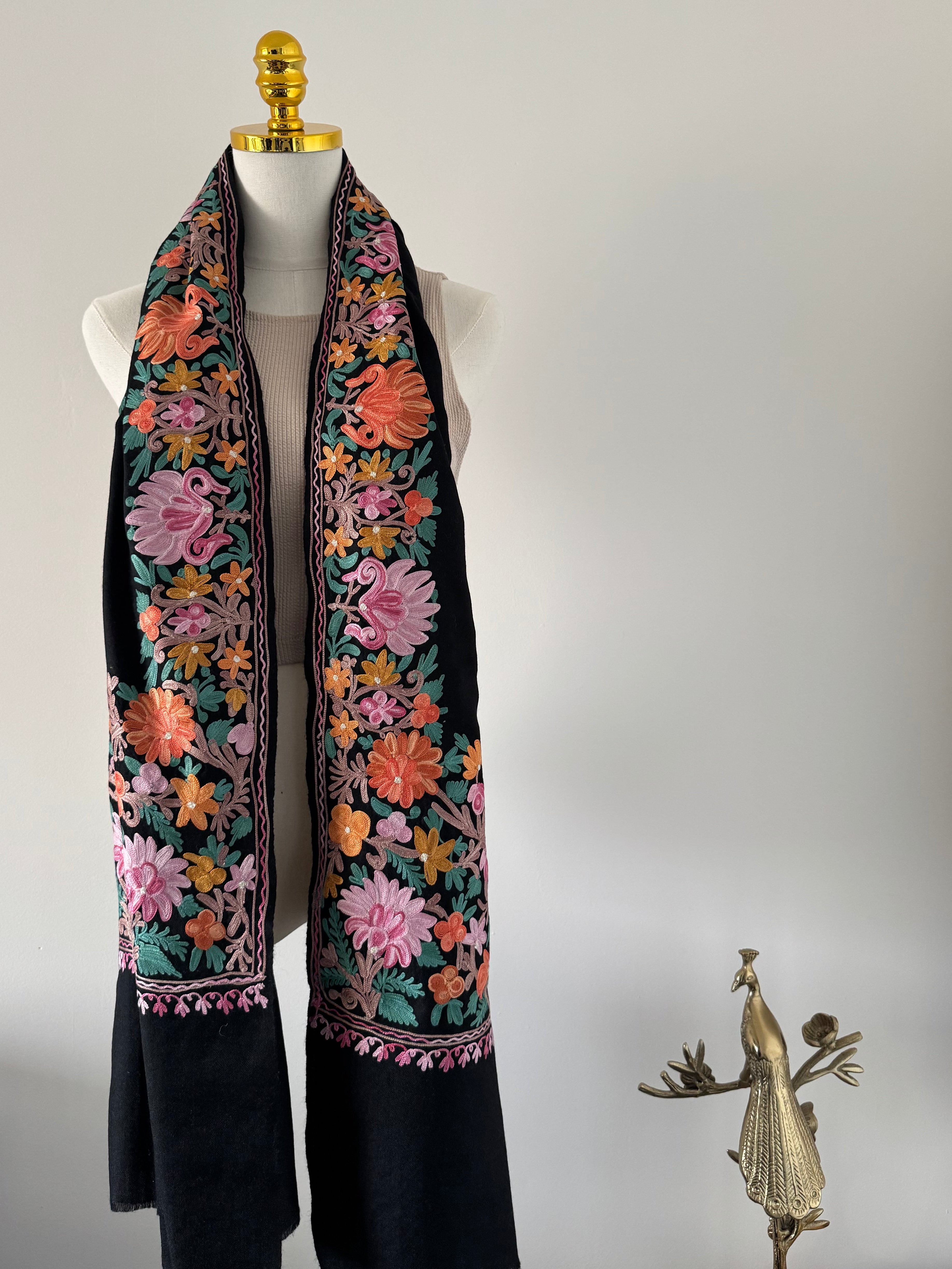 Decorative shawl with floral embroidery on a white background