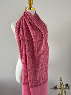 Pink fabric with intricate patterns on a white background