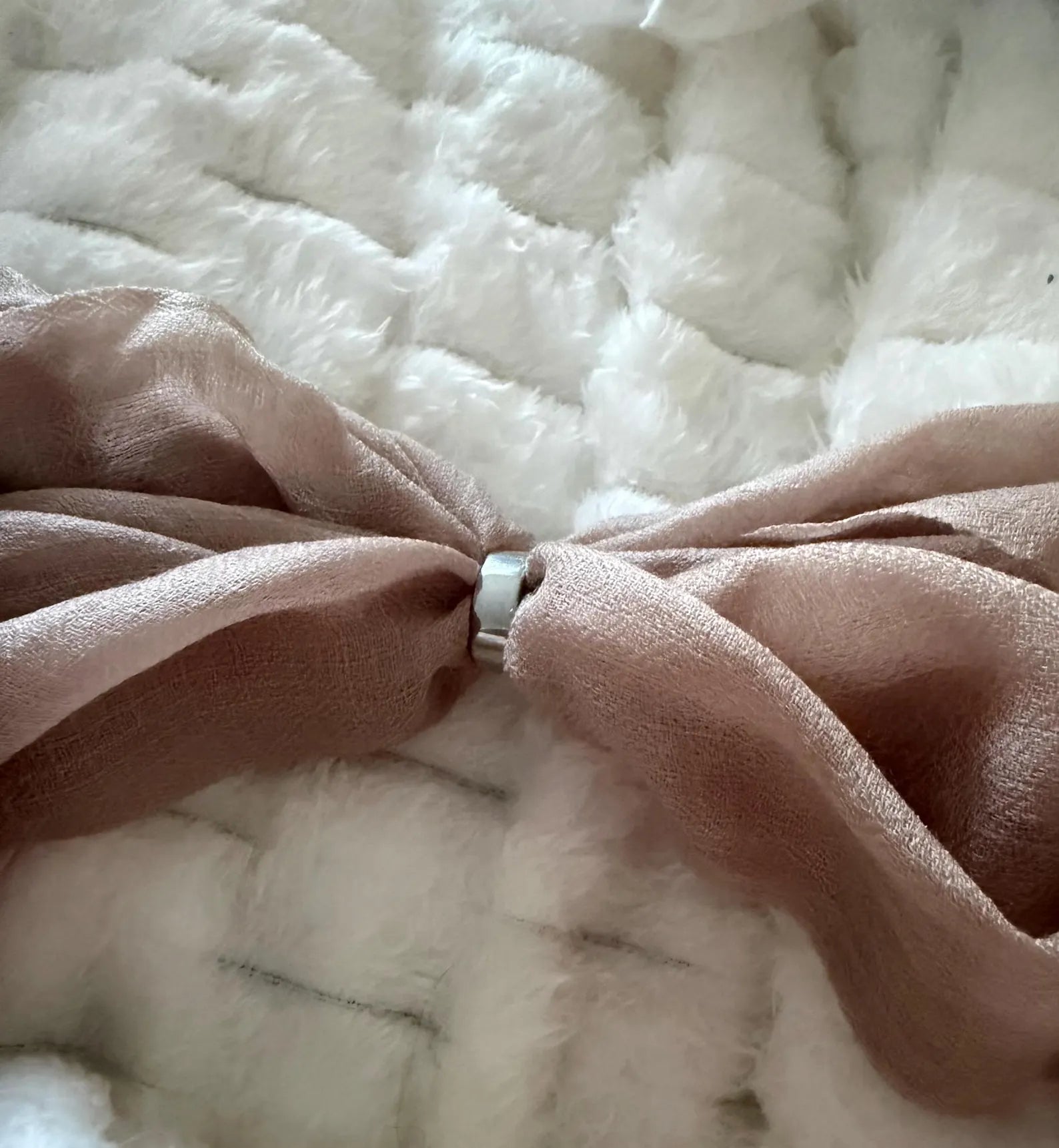Close-up of a brown fabric knot on a textured white background