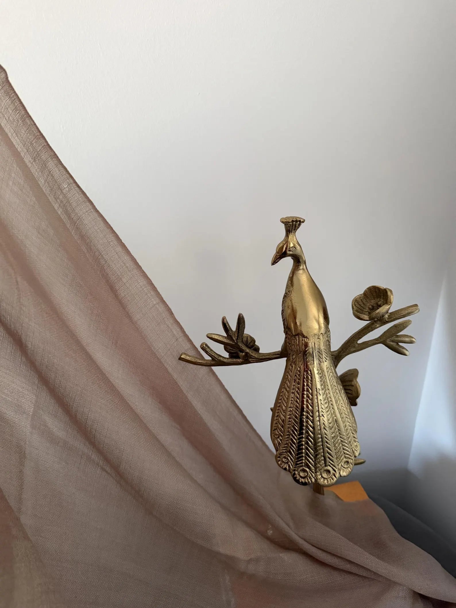 Gold peacock decorative item on a white background