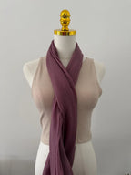 Mannequin wearing a beige sleeveless top with a mauve scarf draped over it on a plain background