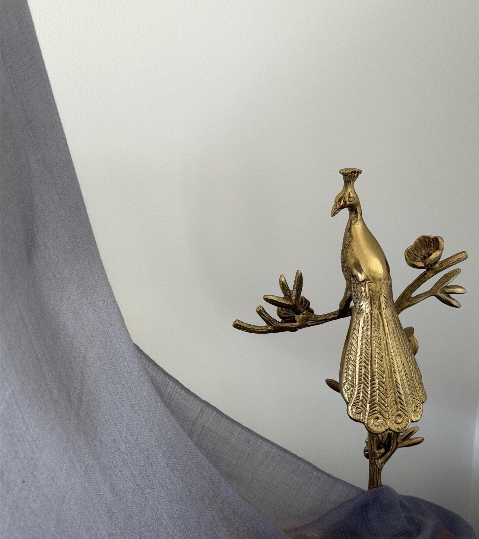 Brass peacock decoration on a white background