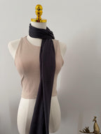 Mannequin wearing a beige sleeveless top with a dark gray scarf draped over it on a plain background.