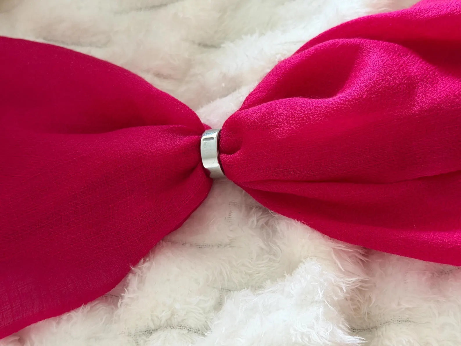 Close-up of a red bow tie on a white fur background