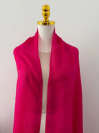 Pink scarf on a mannequin with a plain background