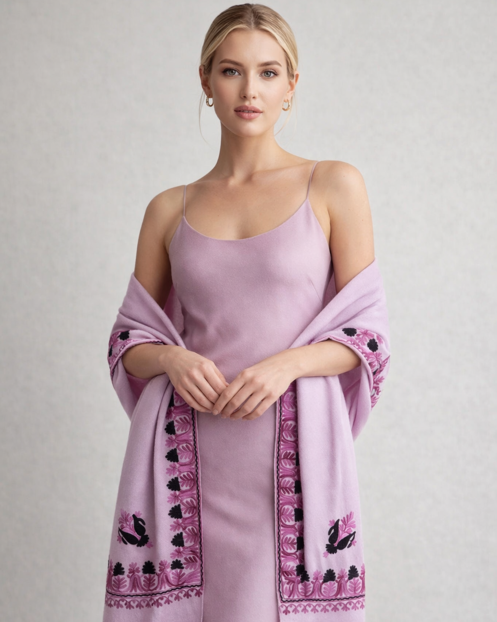 Woman wearing a light purple dress with a matching shawl on a plain background