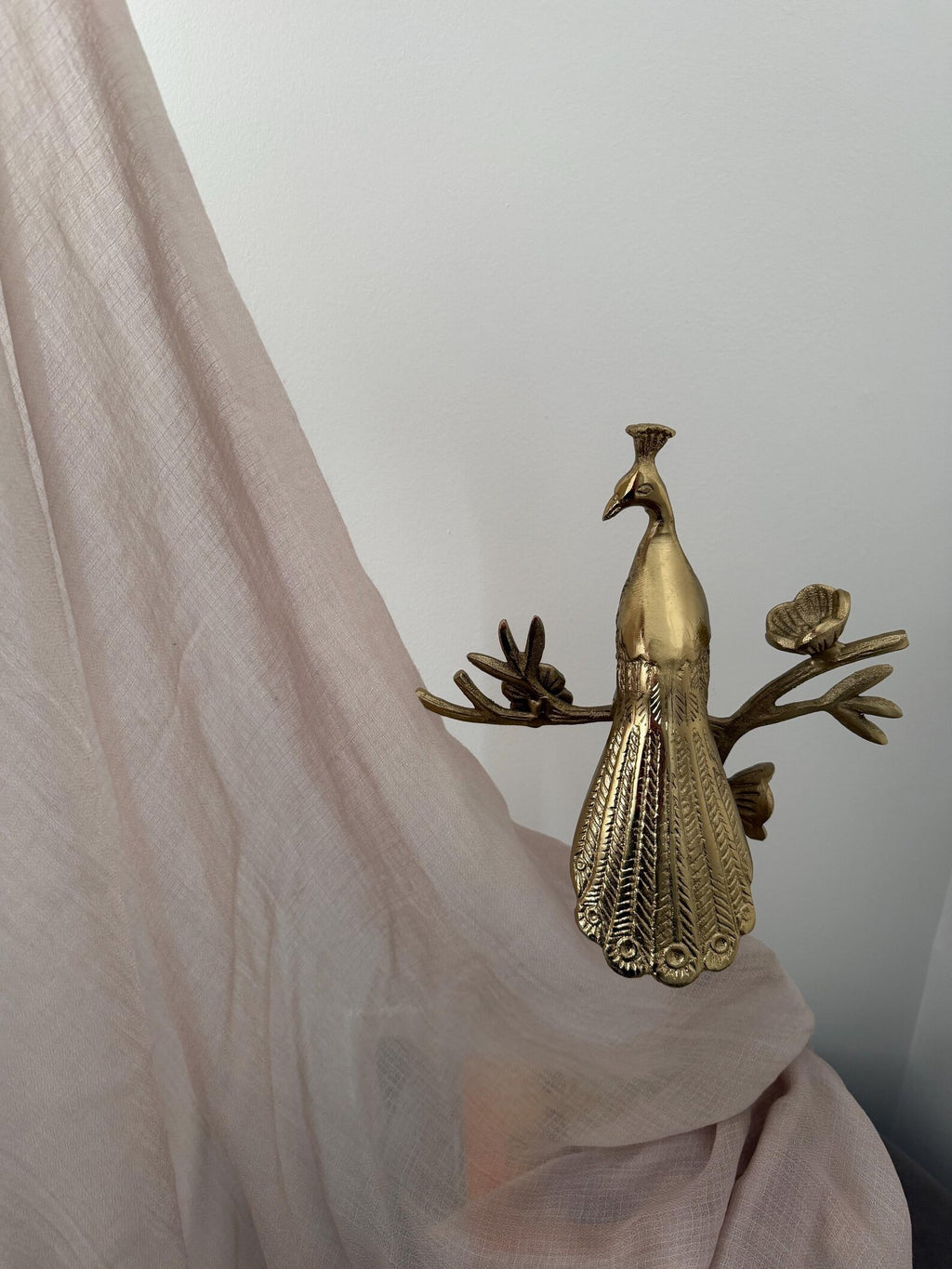 Bronze peacock figurine on a white background
