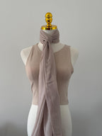 Mannequin wearing a beige ribbed tank top and mauve scarf against a plain background