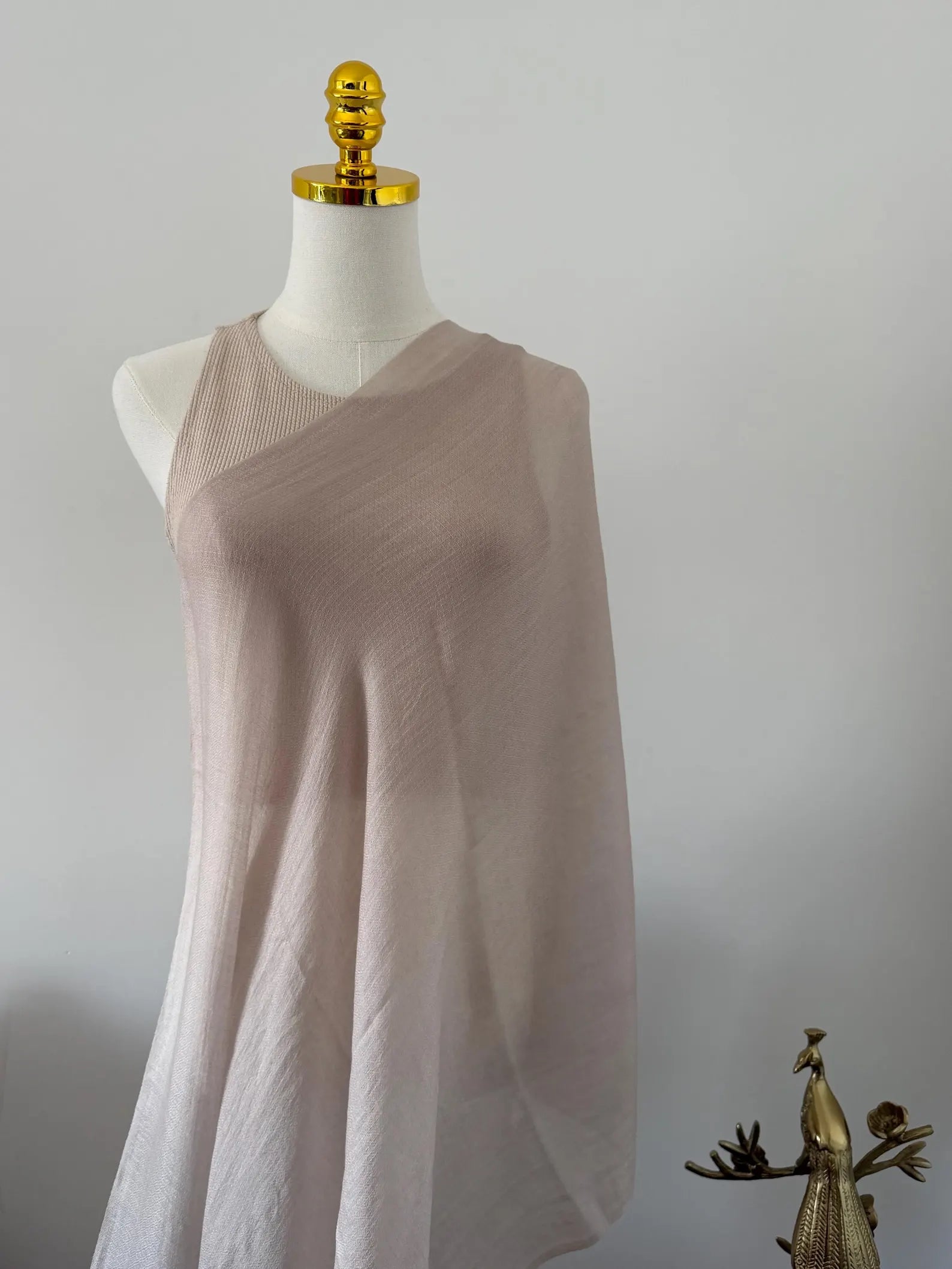 Mannequin wearing a beige sleeveless dress against a plain background